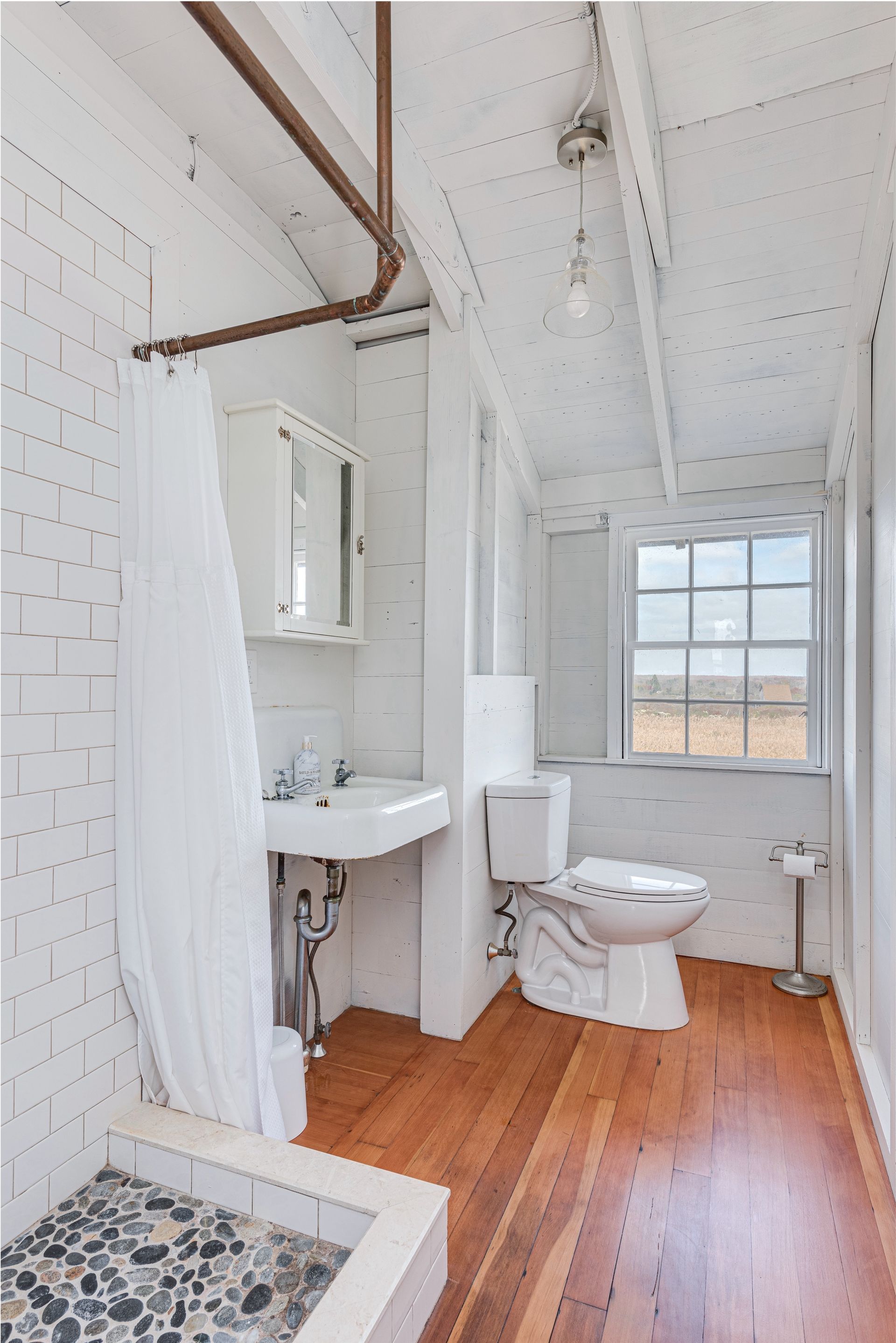 A bathroom with a toilet a sink and a shower