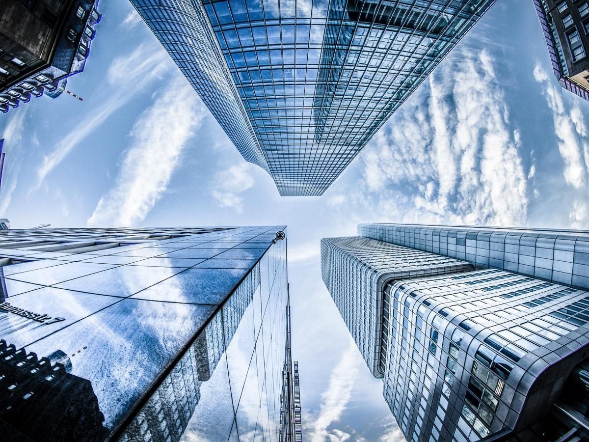 Looking up at a group of tall buildings with a blue sky in the background.