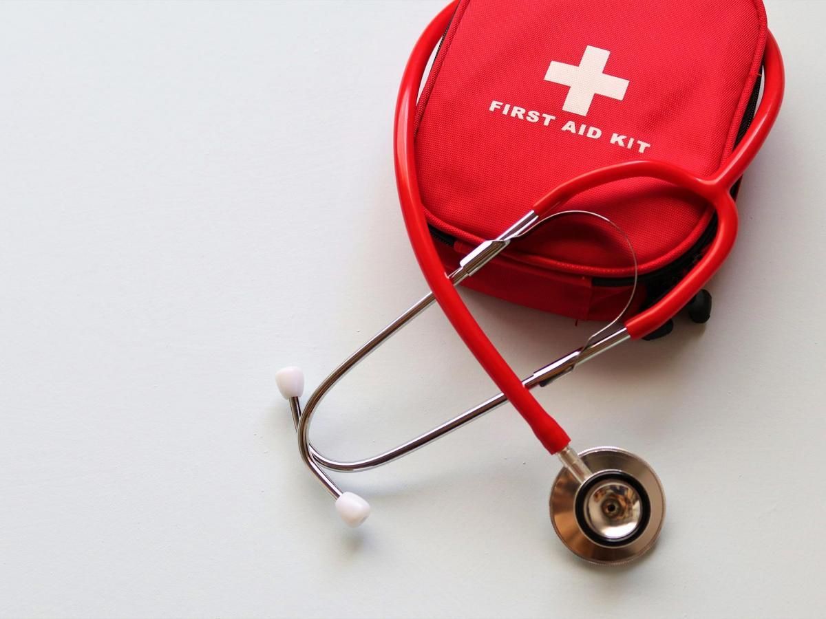 A red first aid kit with a stethoscope attached to it