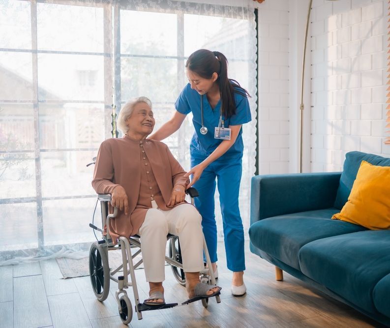 A nurse is helping an elderly woman in a wheelchair.