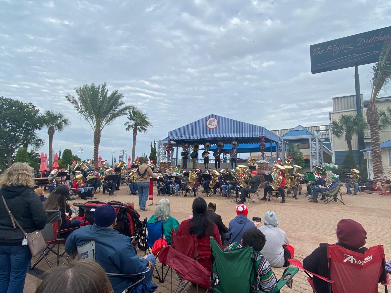 A group of people are watching a band perform on plaza