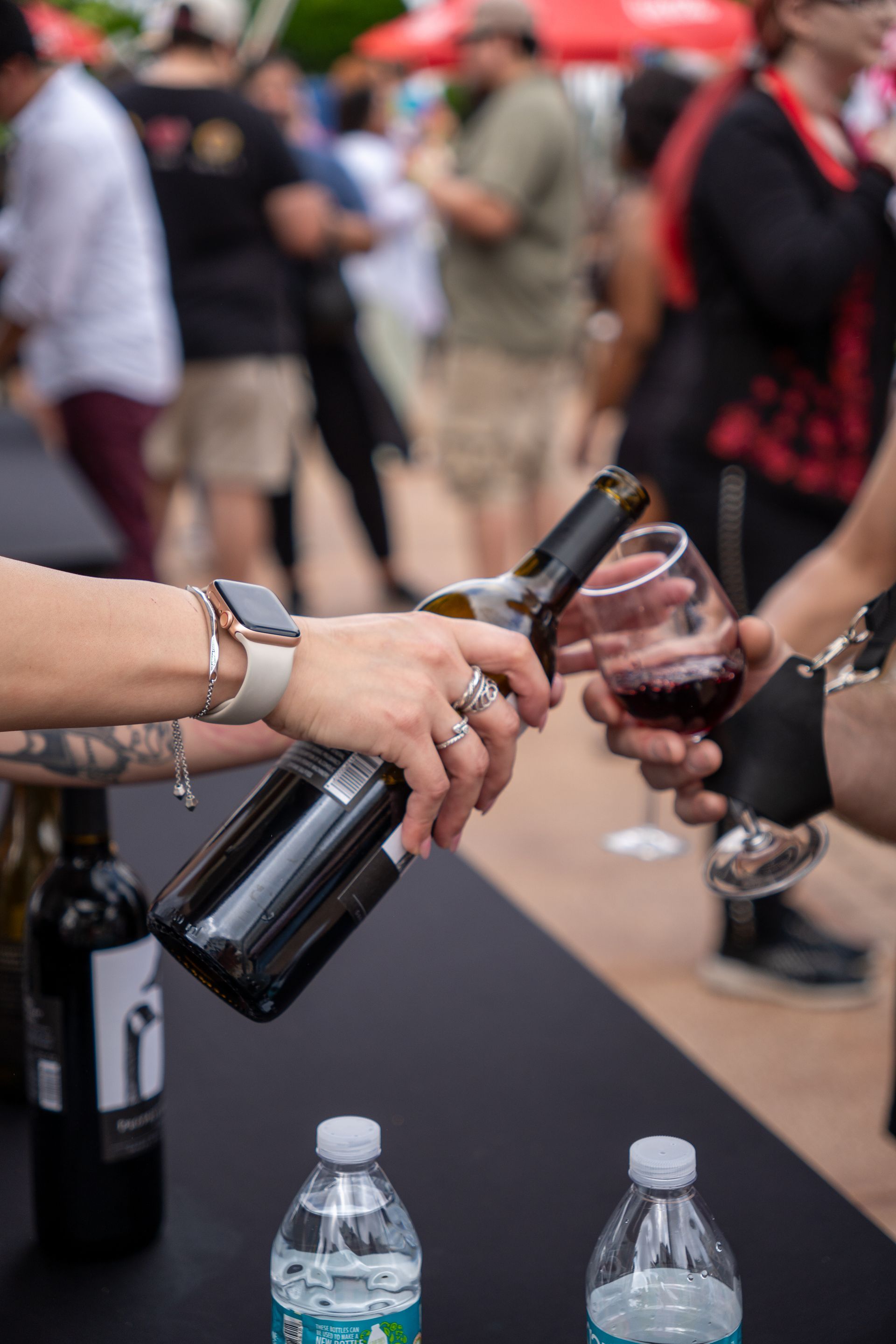 A person pouring a bottle of wine into a glass