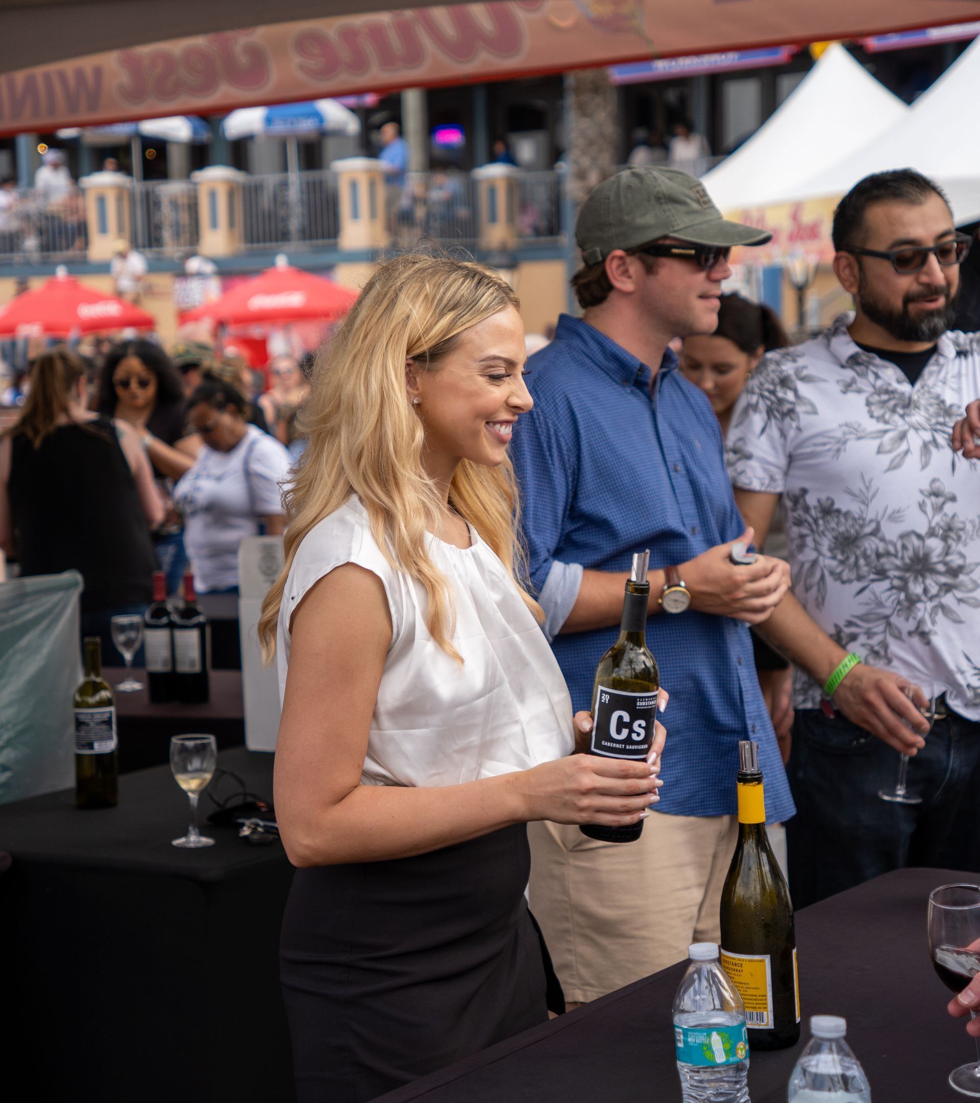 A woman is holding a bottle of cs wine