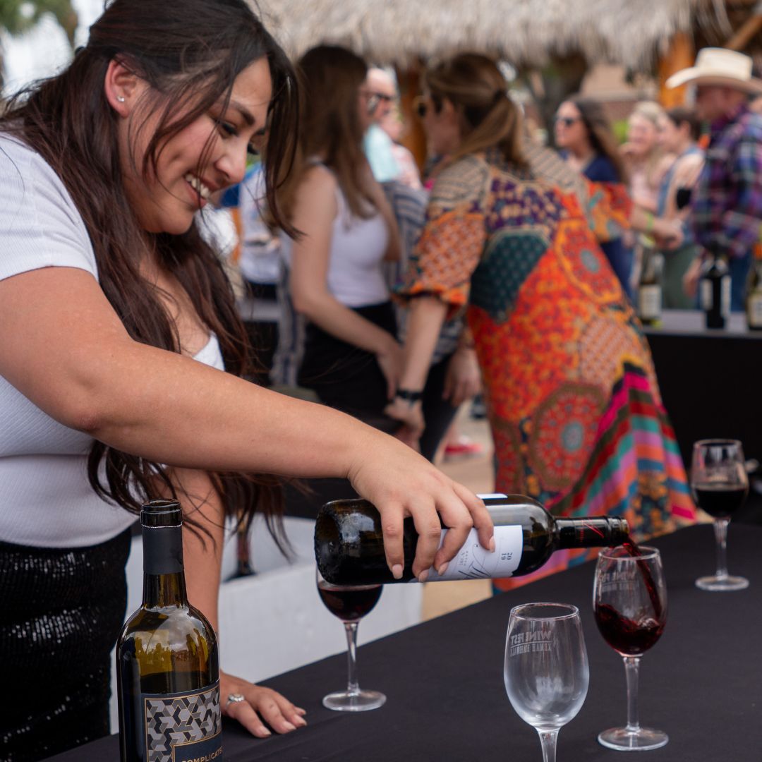 Two people toasting with wine glasses at a festival