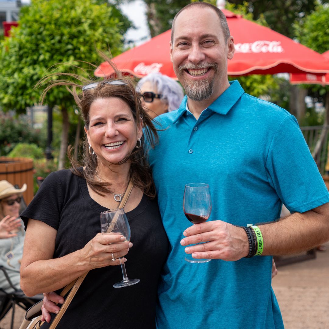 A man and woman are hugging and laughing while a man takes a picture