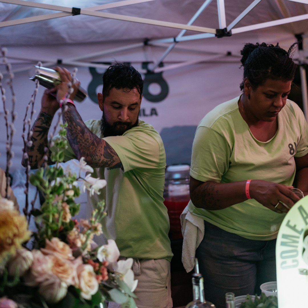 Two people toasting with wine glasses at a festival