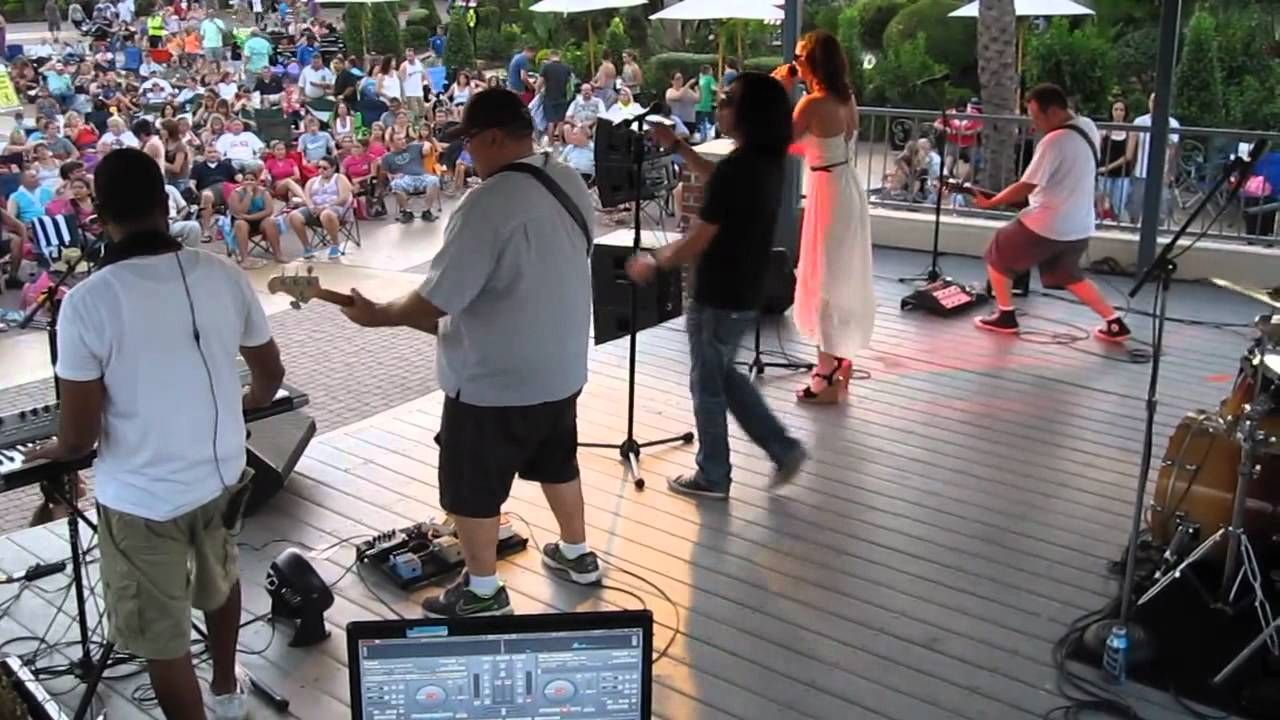 A group of people are playing instruments on a stage in front of a crowd