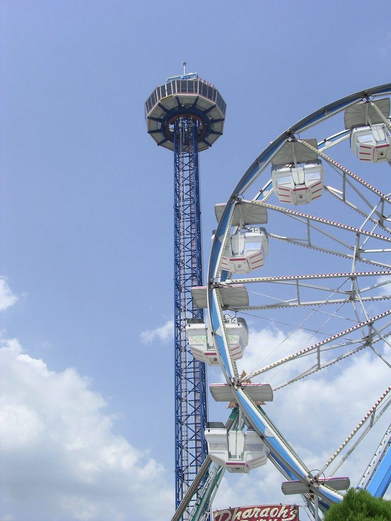 A blue and white ferris wheel is next to a tower
