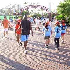 A group of people are walking down a brick sidewalk.