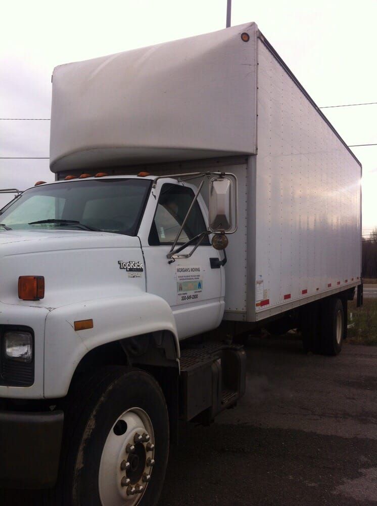 A white truck with a trailer attached to it