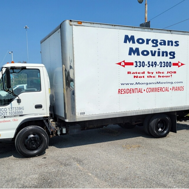 A white morgans moving truck is parked in a parking lot