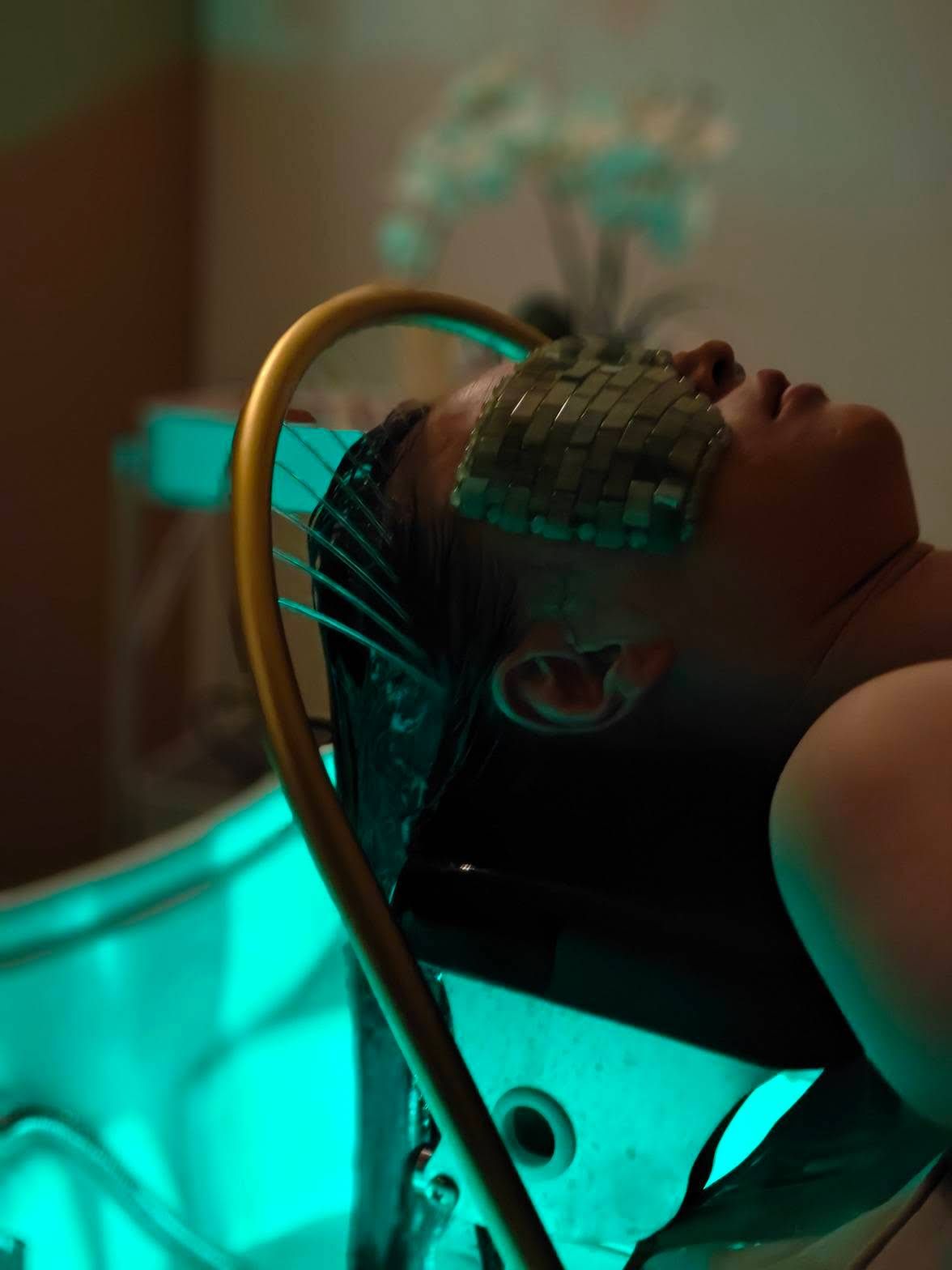 A woman is laying in a bathtub with a mask on her face.