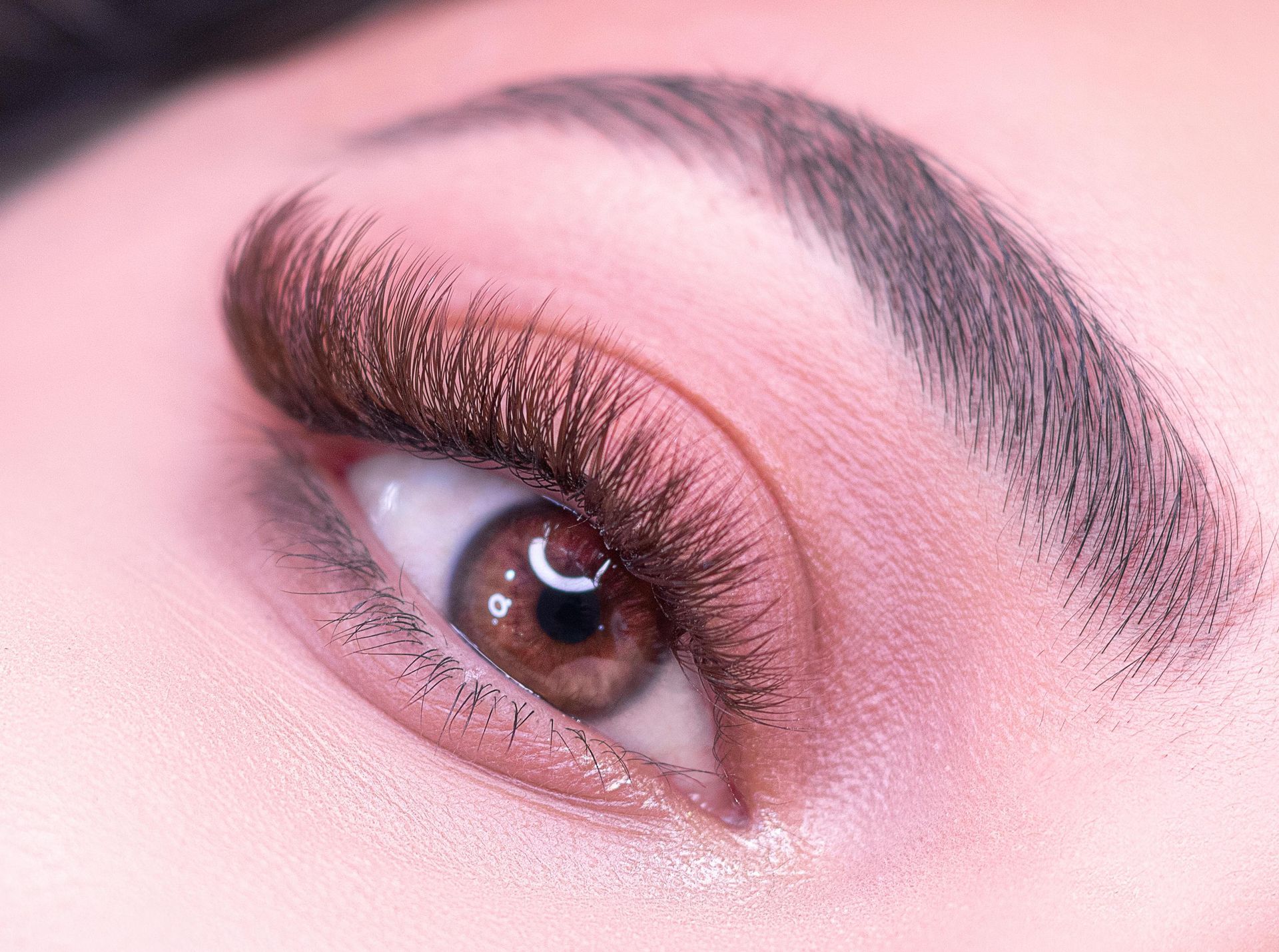 A close up of a woman 's eye with long eyelashes.