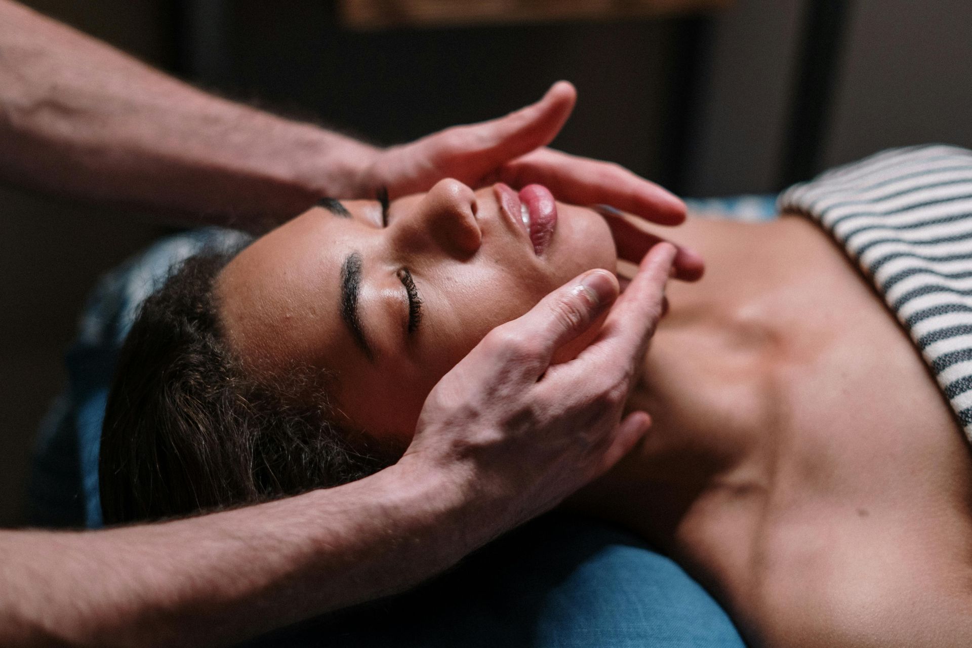 A woman is getting a facial massage at a spa.