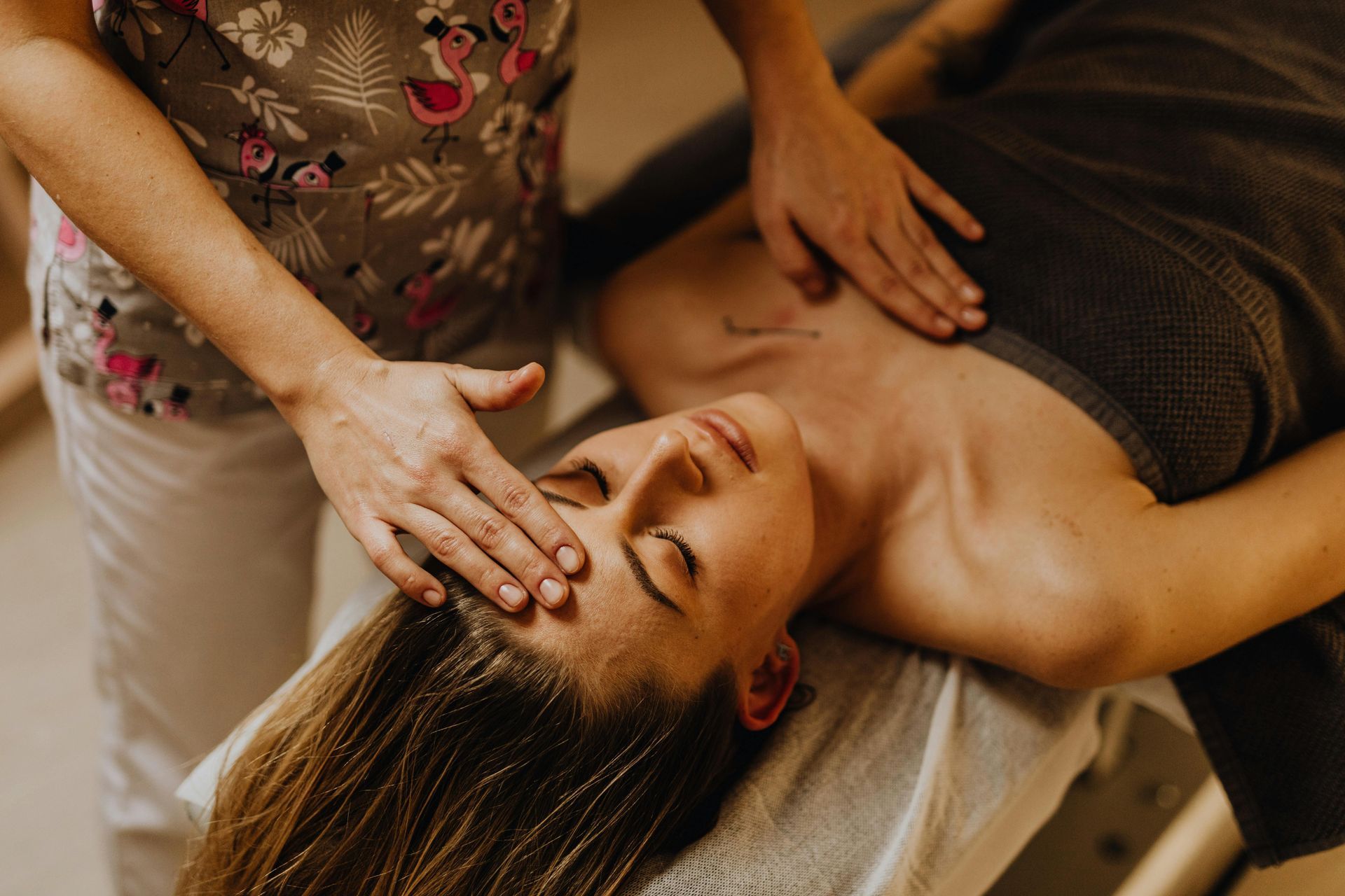A woman is laying on a table getting a massage.