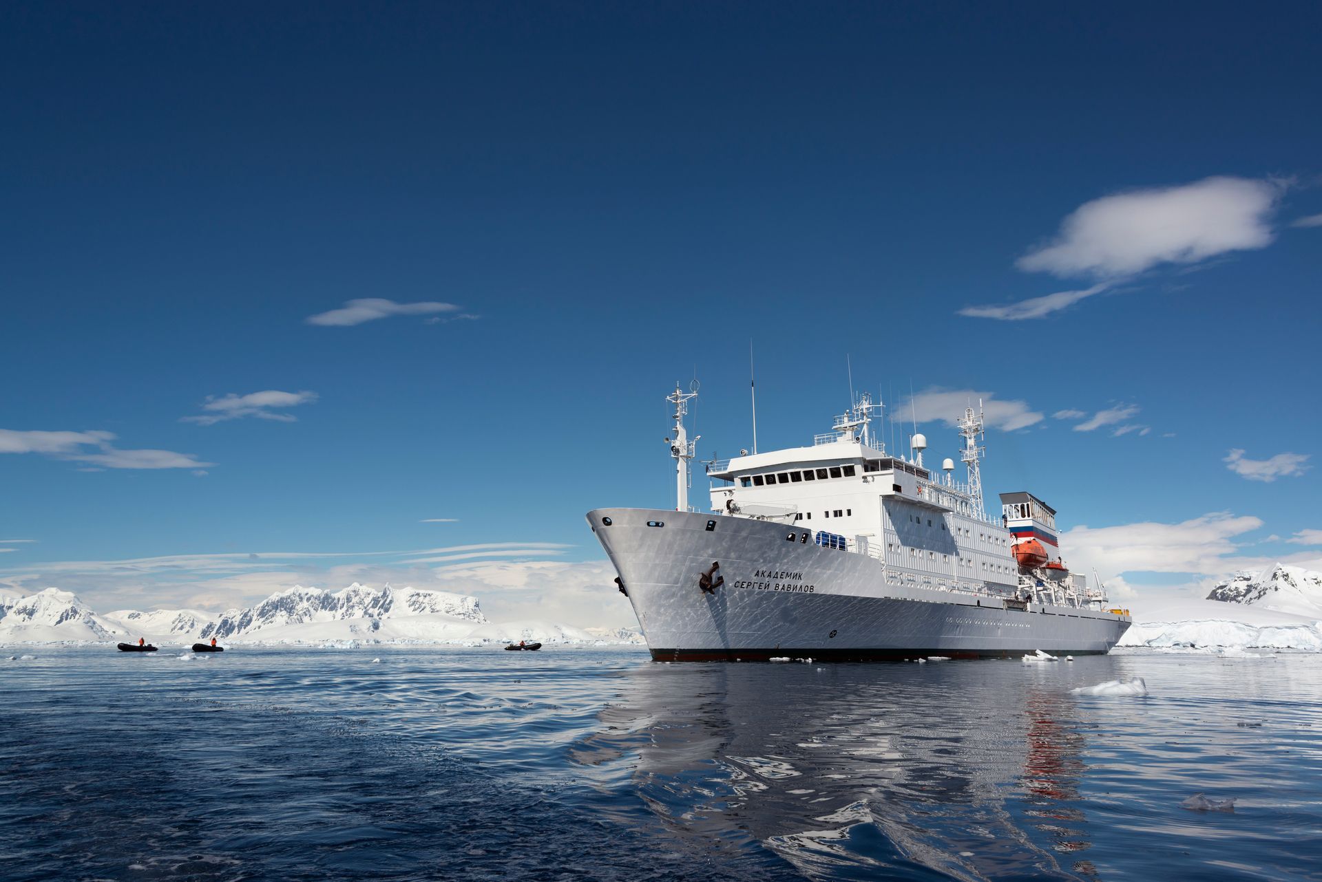 Polar cruise ship in Antarctica representing antarctic cruises with zodiacs navigating icy scene.