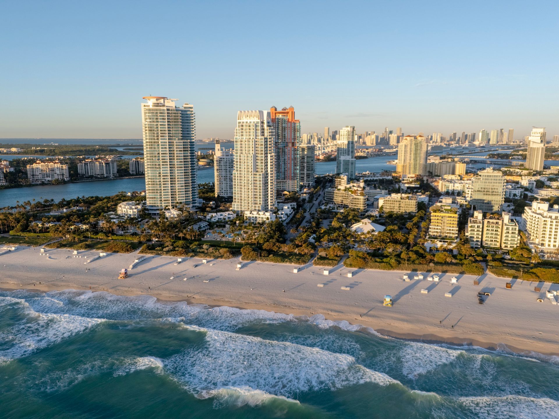 Aerial view of Miami Beach with skyscrapers, white sand beach, and turquoise ocean.