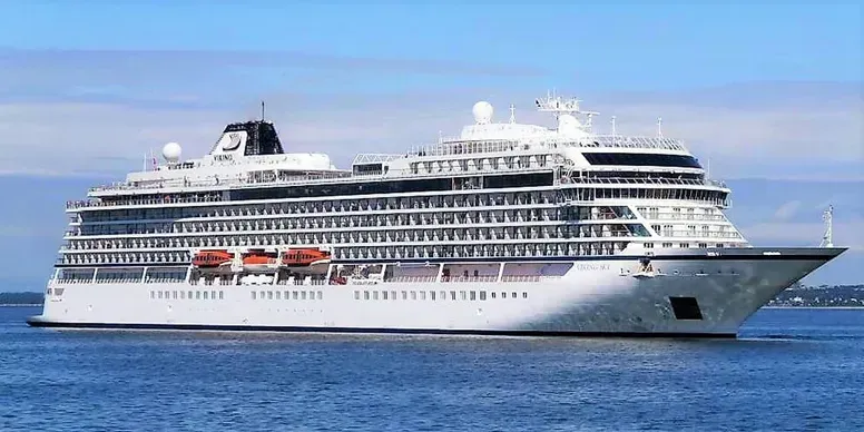 White cruise ship on blue water under a blue sky.