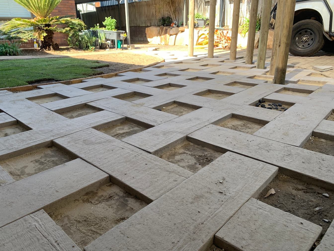 A concrete walkway with holes in it and a truck parked in the background