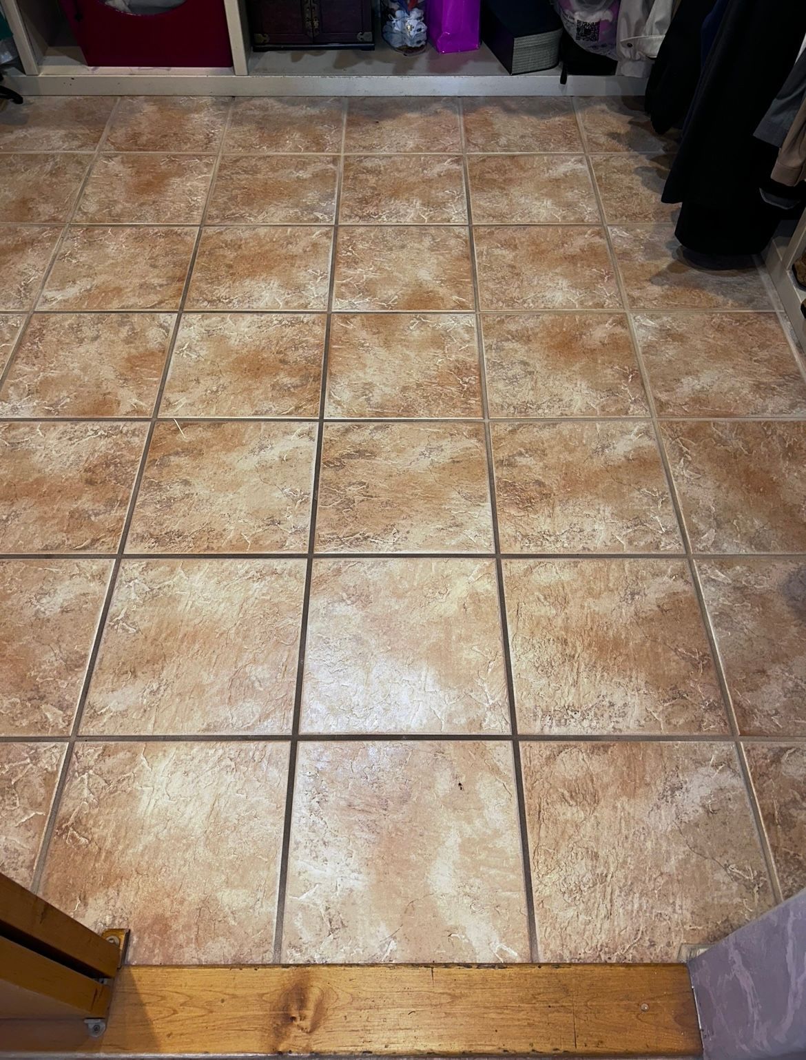 Tiled kitchen floor with tan and brown square tiles, viewed from a doorway.