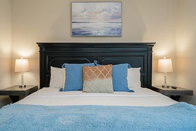 A bedroom with lake colors like light blue used in the interior design of a short-term rental property