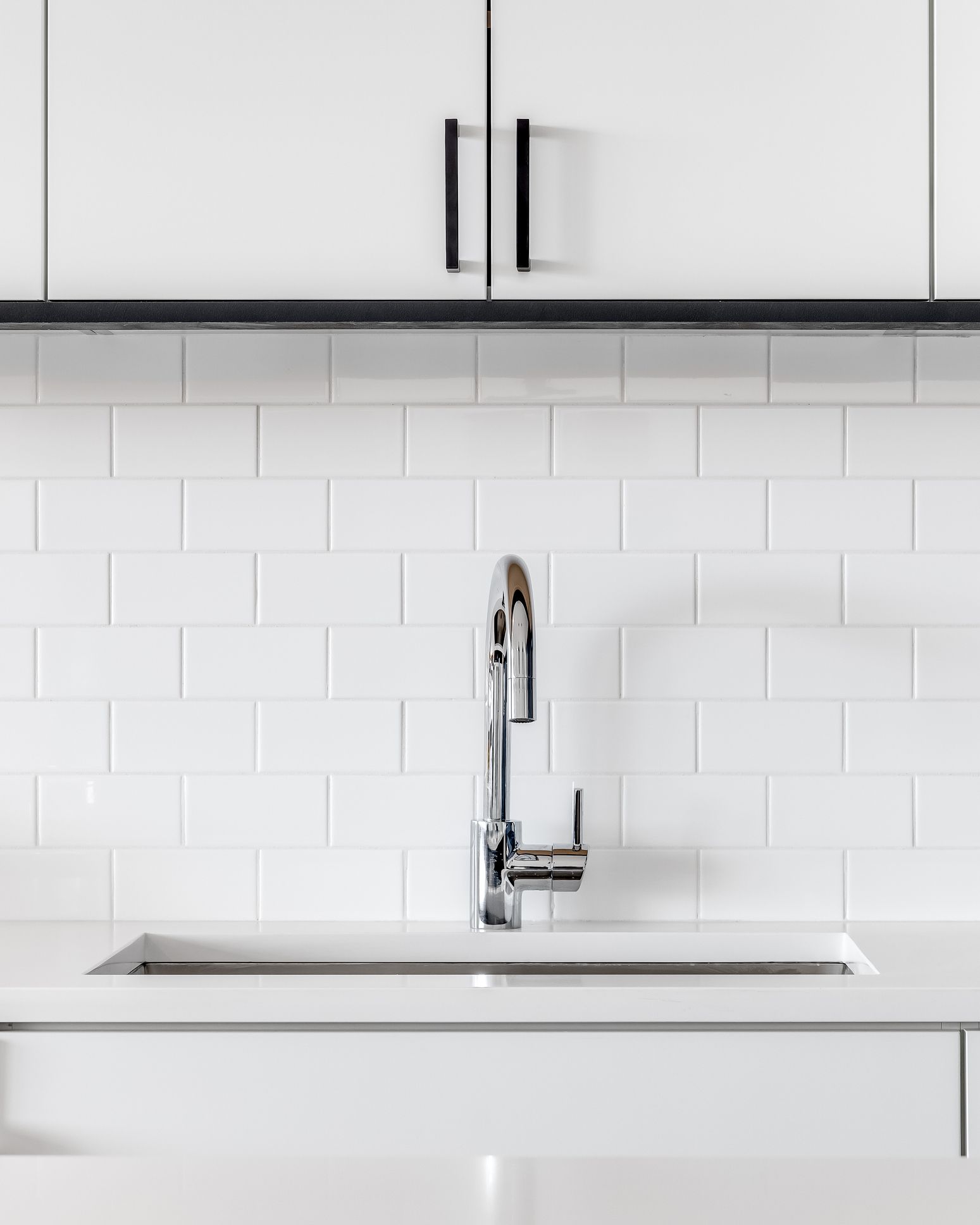 Detail shot of a modern kitchen sink with white cabinets and granite. Detail shot of a modern kitchen sink with white cabinets and granite.