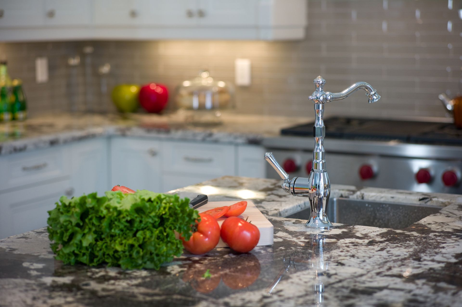 Kitchen counter with vegetables, sink, faucet, and stove. Kitchen counter with vegetables, sink, faucet, and stove.