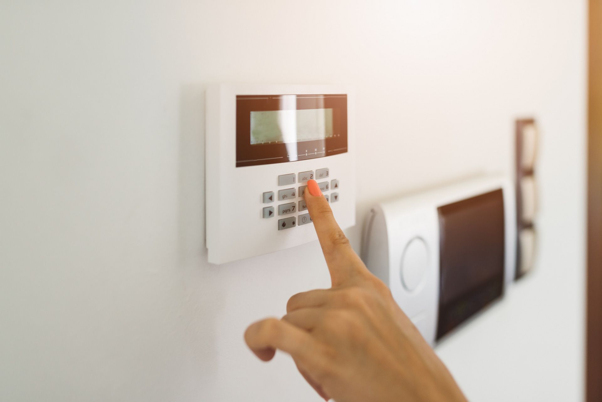 A person is pressing a button on a security system.