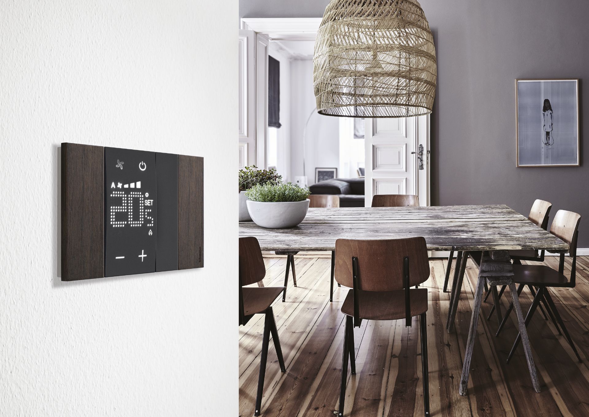 Un termostato intelligente con finiture in legno scuro, montato su una parete bianca e affacciato su una moderna sala da pranzo.