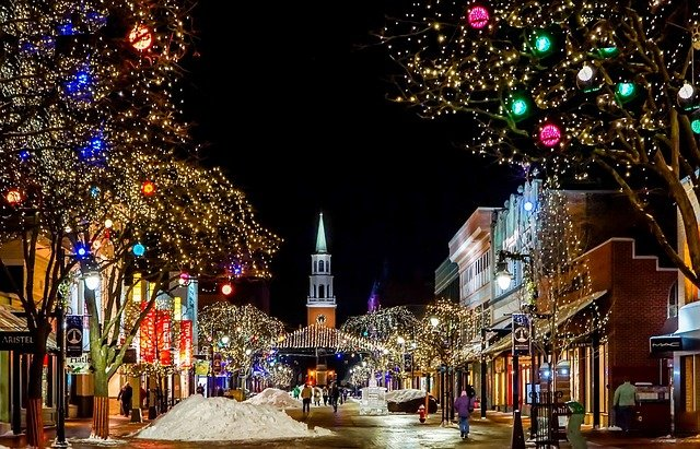 An American city street is decorated with Christmas lights at night.