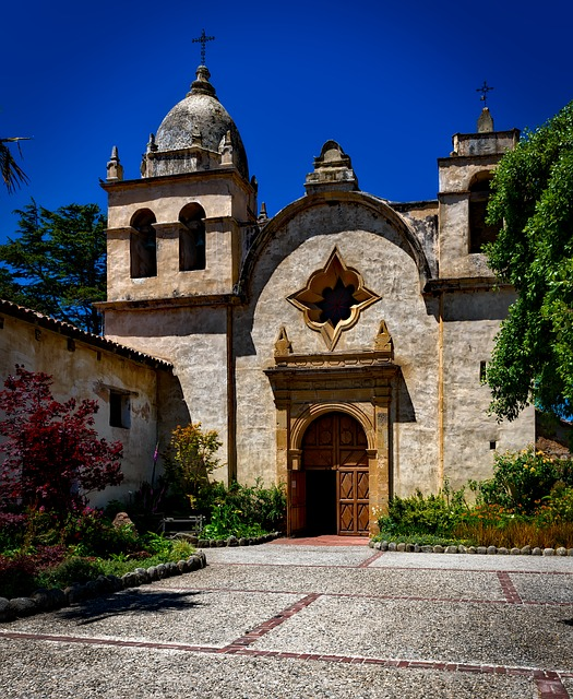 A church with a bell tower and a cross on top in Carmel-By-The-Sea