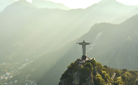 There is a statue of jesus on top of a mountain in Brazil.