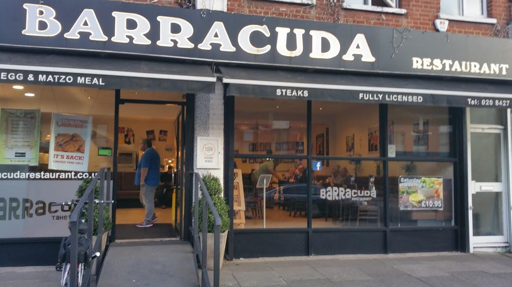 A man is standing in front of barracuda restaurant