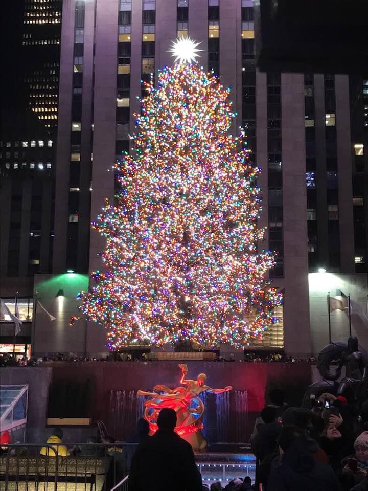 A large Christmas tree is lit up in front of the Rockefeller Center in NYC
