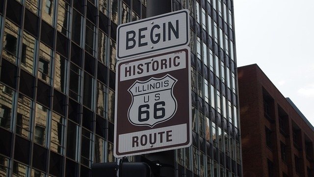 A sign on a pole that says begin historic route 66