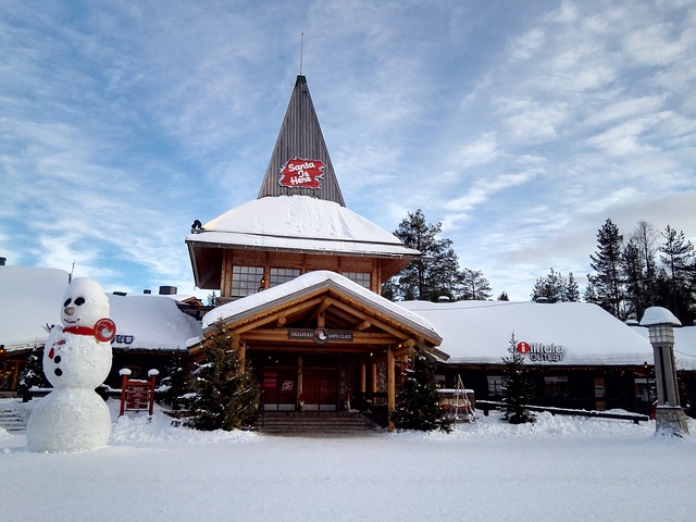 A snowman is standing in front of a snow covered santa claus post office