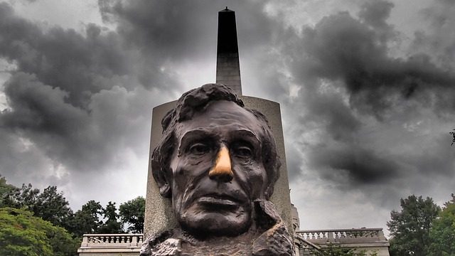 A statue of abraham lincoln is standing in front of a cloudy sky in springfield, illinois
