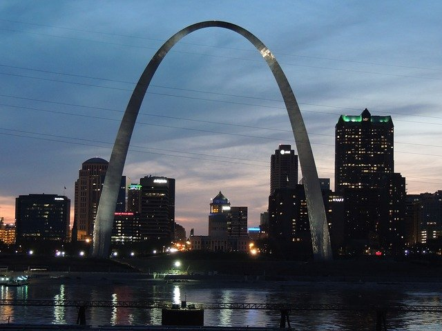 A city skyline with the st. louis arch in the foreground