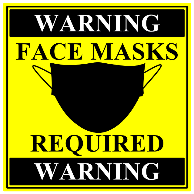 A yellow sign that says warning face masks required warning