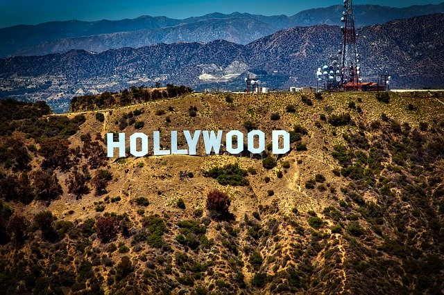 The Hollywood sign is sitting on top of a hill surrounded by mountains.