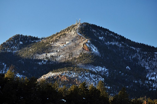 A mountain covered in snow and trees with a blue sky in the background outside williams