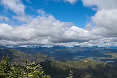 A view of a mountain range with clouds in the sky in white mountain national forest