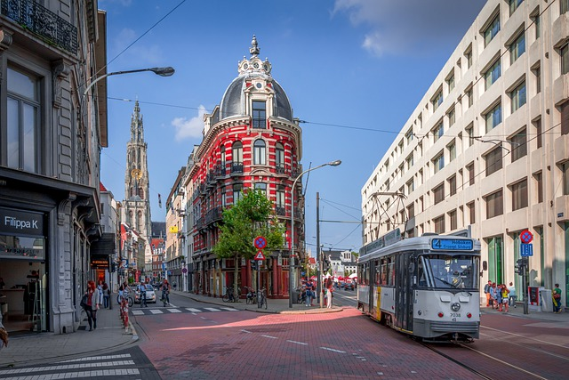 A trolley is driving down a city street next to a large building.