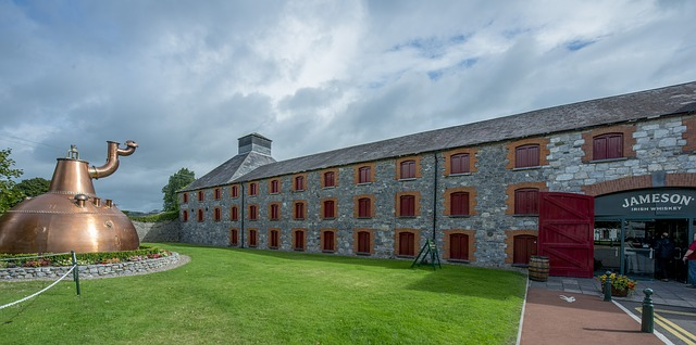 A large copper pot is in front of the jameson distillery