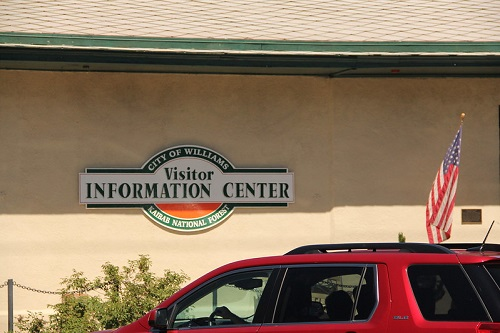 A red van is parked in front of the Williams visitor information center