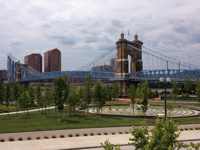 A bridge over a river in a Cincinnati with a park in the foreground.