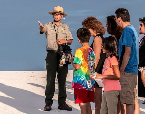 A park ranger is talking to a group of people in white sands national park