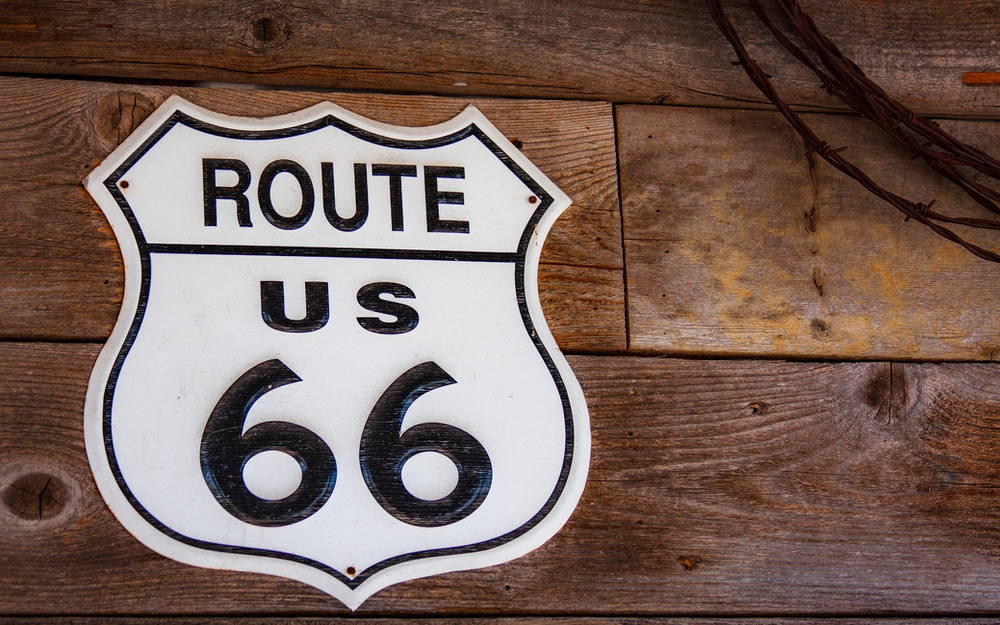 A route 66 sign on a wooden wall