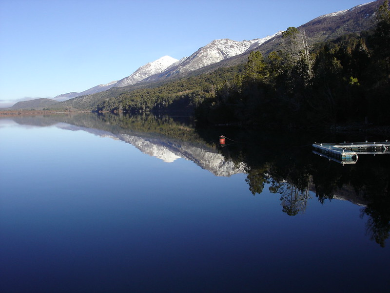 A lake with mountains in the background and trees on the shore