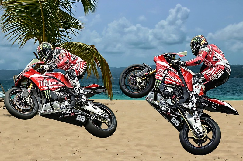 A man is doing a trick on a motorcycle on Daytona Beach.